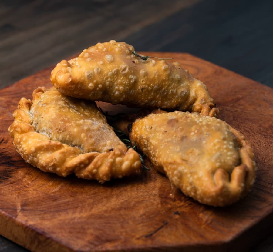 Empanadas crujientes de pescado servidas en una tabla de madera